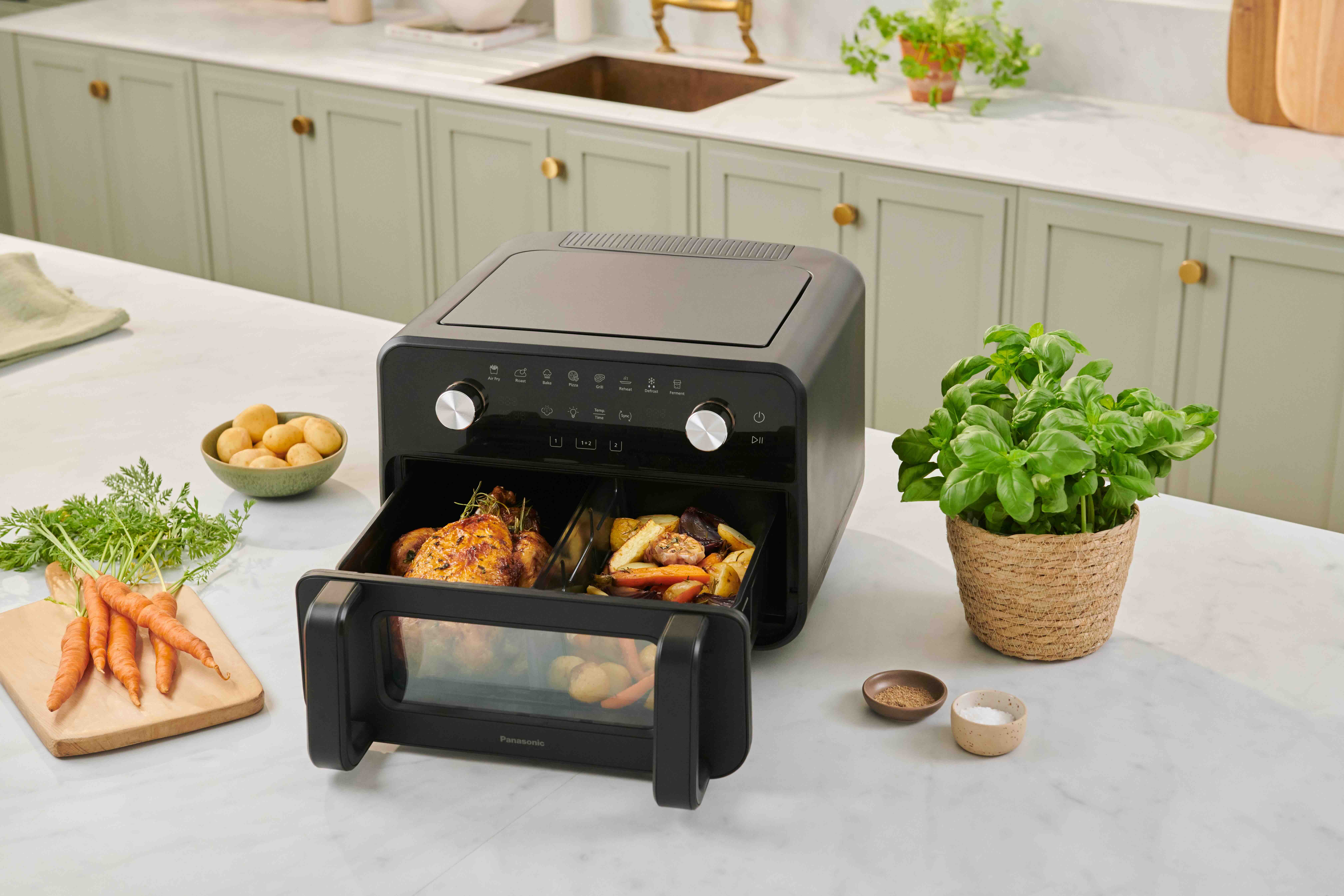 Panasonic Airfryer in K&uuml;chenumgebung, bef&uuml;llt mit Haehnchen und Gemuese